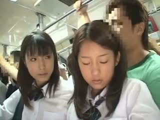 Two schoolgirls ग्रोप्ड में एक बस